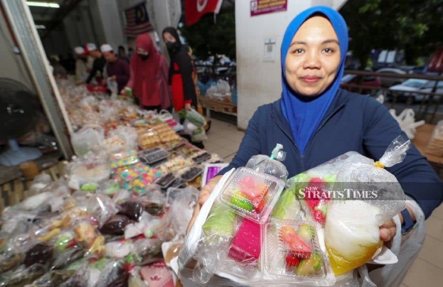 Kuih seller Azizah Salleh, 62, said that she had been selling some 30 different types of kuih-muih, for RM1, since 22 years ago. - NSTP/NIK ABDULLAH NIK OMAR
