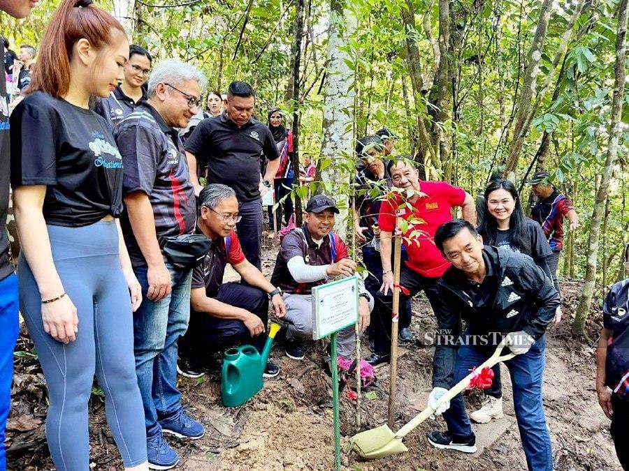 Sabah Chief Conservator of Forests, Datuk Frederick Kugan (right) kicked off the trees planting activities at International Friendship Garden. Photo courtesy of Sabah Forest Department.- NSTP/Paul Mu