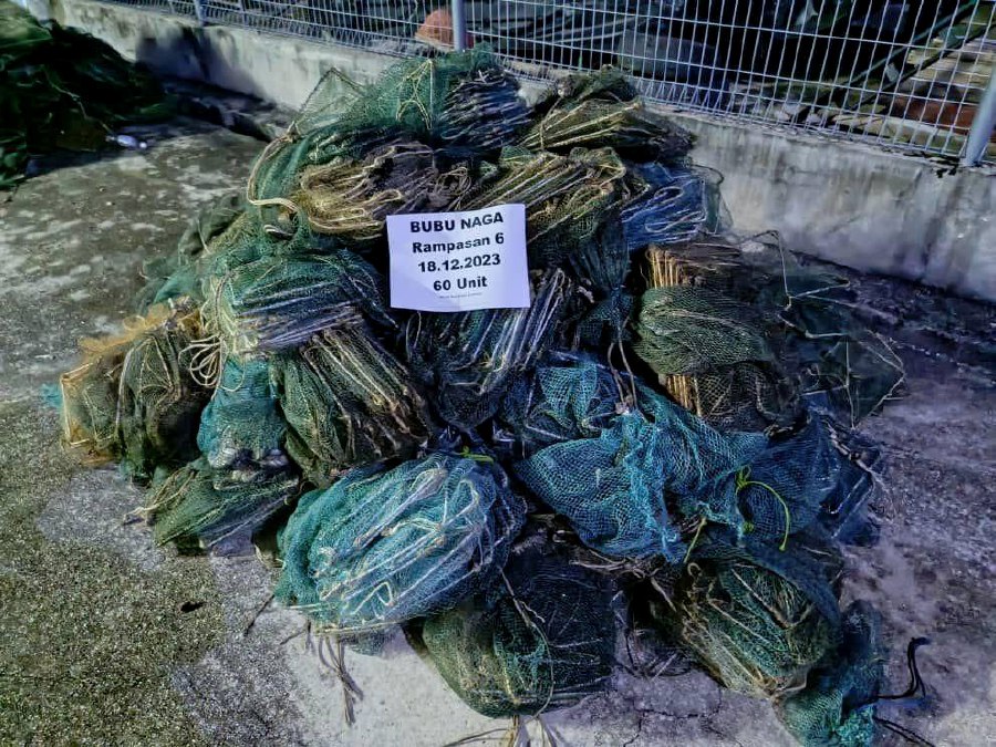 The Malaysian Maritime Enforcement Agency (MMEA) has detained four local fishermen and seized 43 units of banned dragon trap (bubu naga) fishing net in Tanjung Dawai. - Pic courtesy of MMEA 