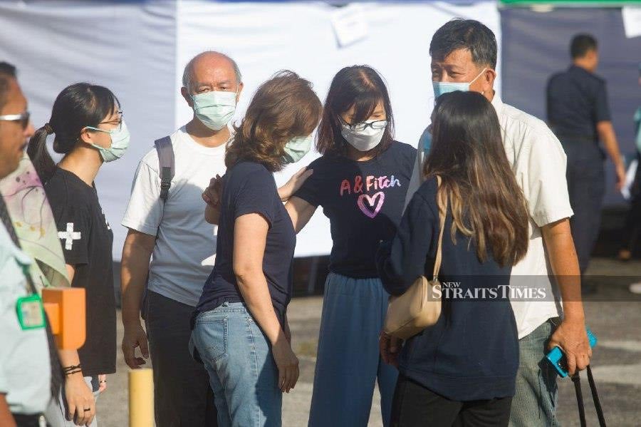 Family members of Daniel Yee Hsiang Khoon, 30, who was one of the victims onboard the BK 160 Gabriel light aircraft that crashed yesterday was seen hugging and comforting each other after completing their DNA sample. - NSTP/GENES GULITAH