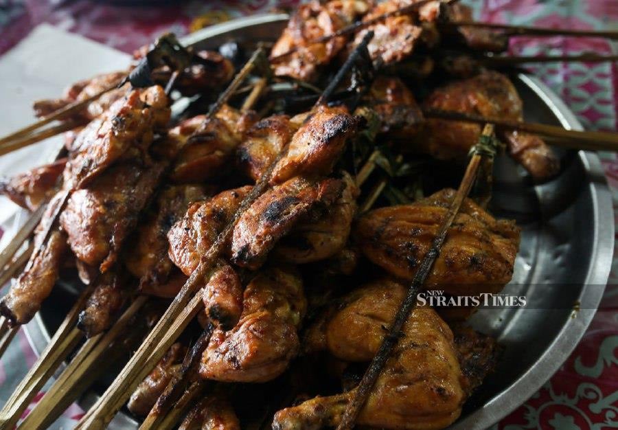 The owner of Kak Jah Grilled Chicken, Wan Marini Wan Mohd Nazi, 41, said that some of her regular customers residing in Kuala Lumpur would purchase round-trip tickets within a day just to taste the “ayam percik” as their main dish for breaking fast. - NSTP/NIK ABDULLAH NIK OMAR