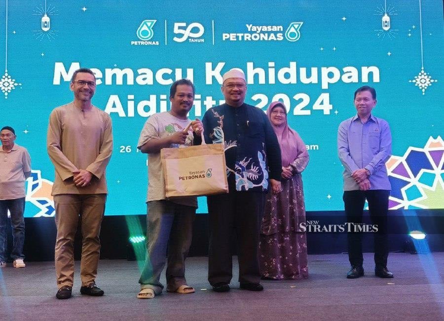 The donation was presented by Petronas East Coast general manager Mohamad Ahmad Shazly Ramli to state Welfare director Said Sidup witnessed by Kelantan deputy Menteri Besar Datuk Dr Mohamed Fadzli Hassan. - NSTP/NIK ABDULLAH NIK OMAR