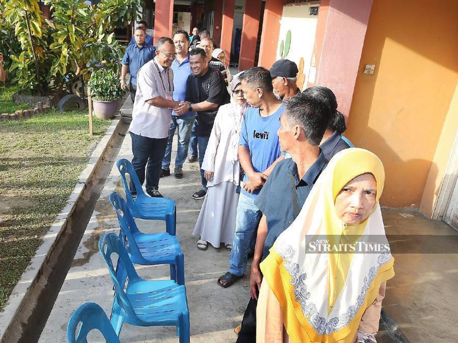  Perikatan Nasional (PN) candidt, Khairul Azhari Saut (left) mingles with voters in Kuala Kubu Bharu. - NSTP/SAIFULLIZAN TAMADI