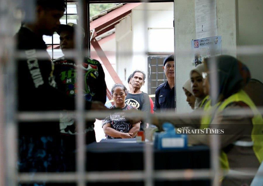 Orang Asli voters waiting in line to cast their vote at the Pusat Mengundi, Pusat Pembangunan Pendidikan Peretak, Kampung Orang Asli Peretak. - NSTP/EIZAIRI SHAMSUDIN