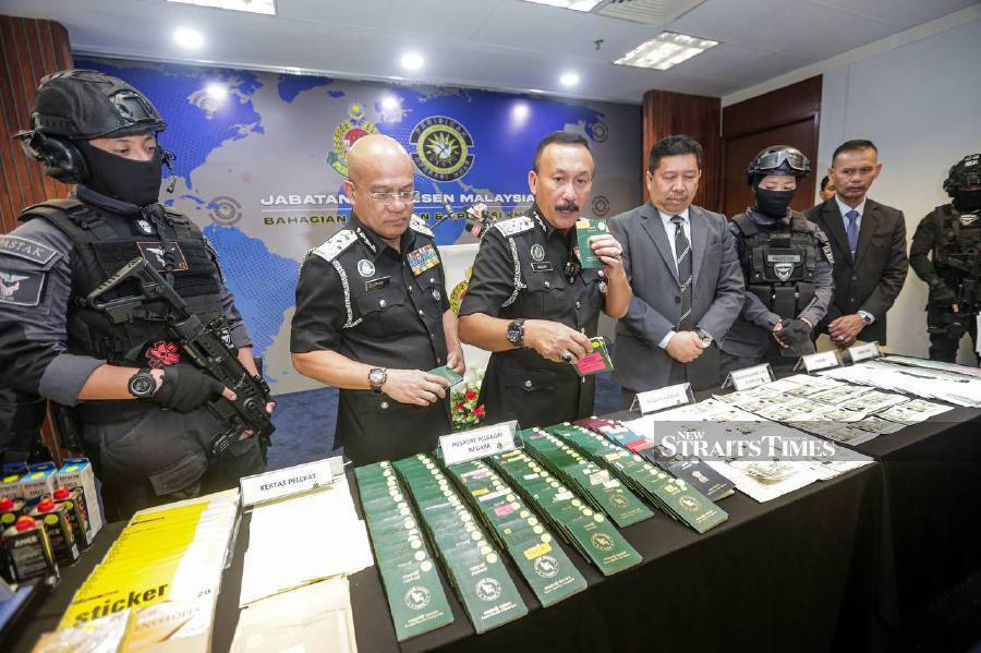 Immigration Department director-general Datuk Ruslin Jusoh displaying several of the items seized from a syndicate falsifying foreign passports. NSTP/HAZREEN MOHAMAD
