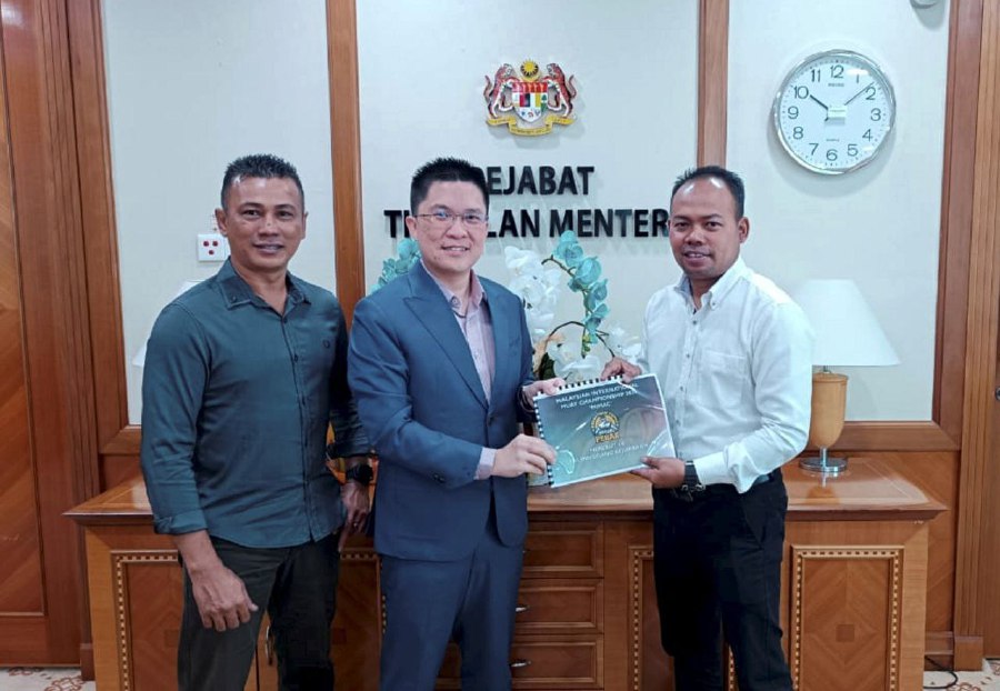 PUTRAJAYA - President of the Perak Tomoi Association (PTNP) Mohd Ezry Azamin (right), presenting a proposal for the International Tomoi Championship for the Wong Kah Woh championship belt as part of the 150th anniversary celebration of Taiping to deputy education minister Wong Kah Woh during a courtesy visit to the latter's office in Putrajaya. With them is PTNP Sports Development Exco, Nazri Nasiman. -PIC courtesy of deputy minister's office