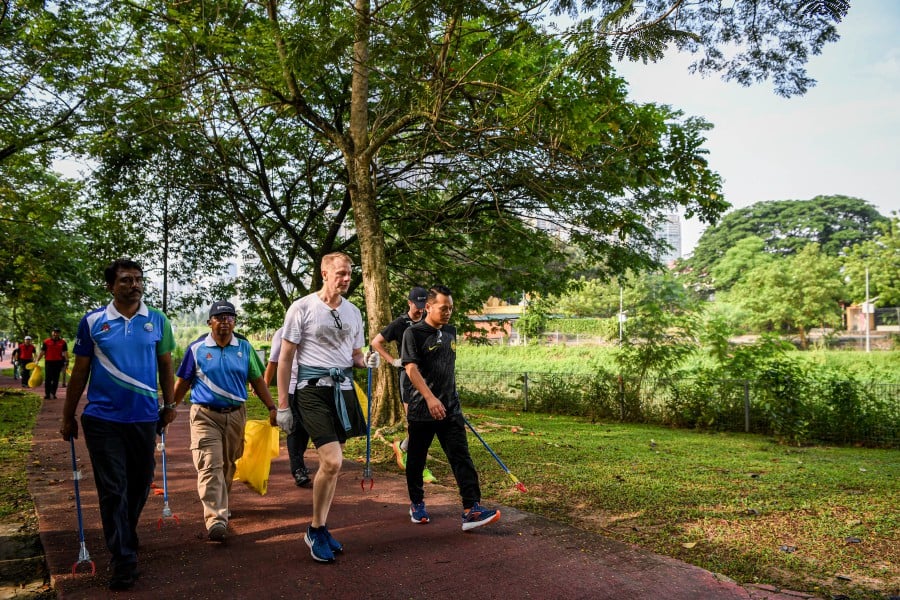 Natural Resources and Environmental Sustainability Minister Nik Nazmi Nik Ahmad (right) and Swedish Ambassador Dr Joachim Bergstrom (second from right) participating in a plogging programme in conjunction with Earth Day 2024 organised by the Swedish Embassy in collaboration with the Kuala Lumpur City Hall and the Malaysian National News Agency (Bernama) at the Sungai Bunus Urban Garden here today. Bernama pic