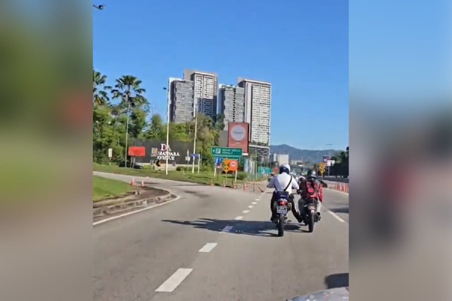 Policemen from the Petaling Jaya Traffic Enforcement and Investigation Department went beyond their duty to aid a motorcyclist who found himself stranded on an expressway after running out of fuel yesterday. - Screenshot from TikTok