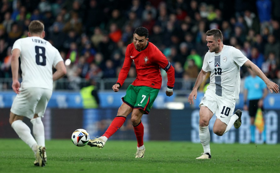 Portugal's Cristiano Ronaldo in action with Slovenia's Timi Max Elsnik. (REUTERS/Borut Zivulovic)