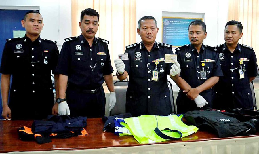  District police chief Assistant Commissioner Mohd Azhar Hamin (center) said the 30-year-old foreigner was apprehended when boarding a vehicle in a suspicious manner at Batu 3 here on Wednesday. Pic by STR/HAZSYAH ABDUL RAHMAN 