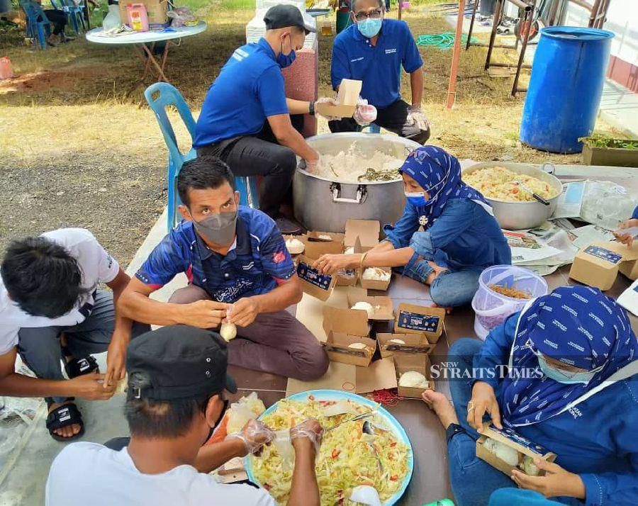Volunteers getting cooked food ready for distribution. - NSTP/ZAINAL AZIZ