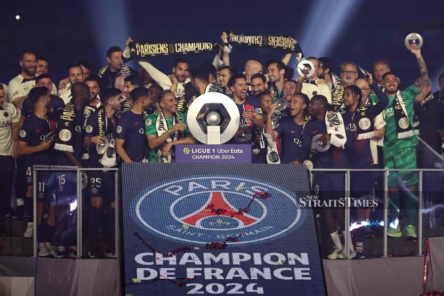 Paris Saint-Germain players celebrate with the French Ligue 1 championship trophy during a ceremony following the match between PSG and Toulouse at the Parc des Princes Stadium in Paris on Sunday. - AFP PIC