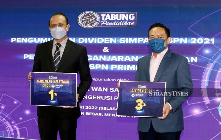 National Higher Education Fund Corporation (PTPTN) chairman Datuk Wan Saiful Wan Jan (right) and chief executive officer Ahmad Dasuki Abdul Majid holding posters at a ceremony to announce a three per cent dividend for SSPN Savings depositors in Kuala Lumpur yesterday. - NSTP/HAIRUL ANUAR RAHIM 