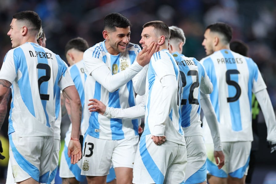 Argentina's Giovani Lo Celso is congratulated by Cristian Romero after scoring a goal against El Salvador at Lincoln Financial Field in Philadelphia, Pennsylvania. - AFP PIC