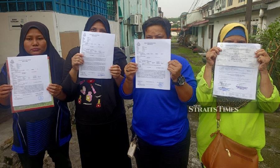Some of the Kempas Permai People's Housing Project (PPR) residents showing the police reports lodged at the Skudai police station. - NSTP/Mary Victoria Dass 
