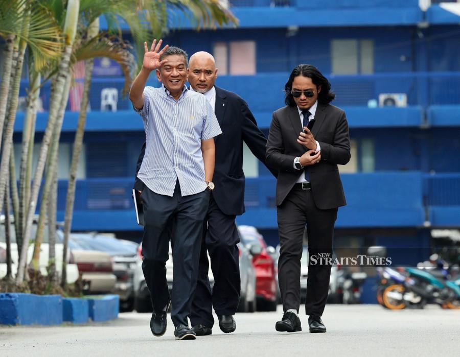  Datuk Dr Mohammad Agus Yusoff (left) waves at pressmen after arriving at the Kajang district police headquarters. -NSTP/FATHIL ASRI
