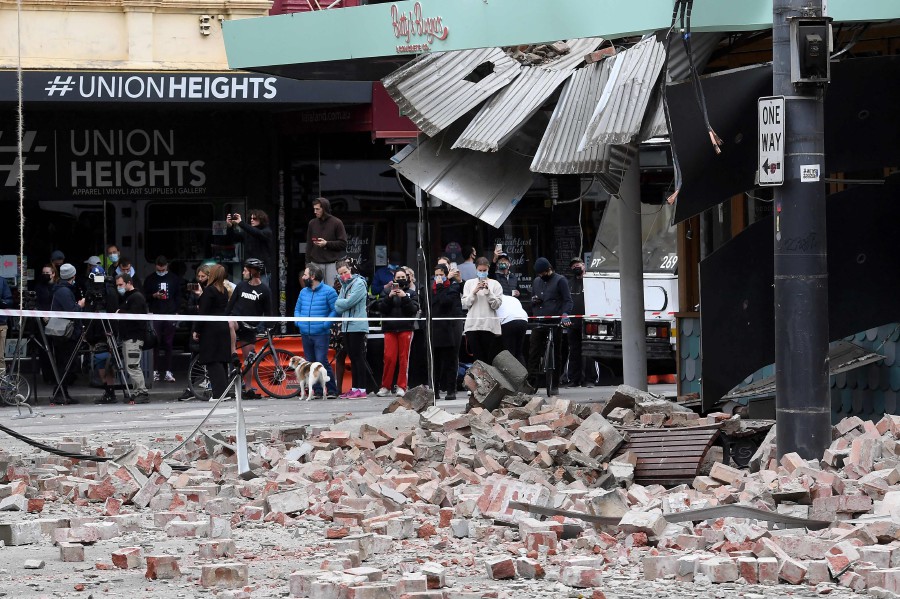 Residents gather near a damaged building in the popular shopping Chappel Street in Melbourne. - AFP PIC