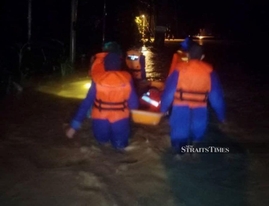 This October 26 pic shows Civil Defence Force personnel inspecting the flood situation in Baling. - Puc courtesy of Civil Defence Force. 