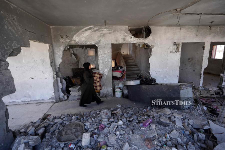 Palestinians salvage items from a damaged building as they prepare to flee Rafah in the southern Gaza Strip. - AFP PIC