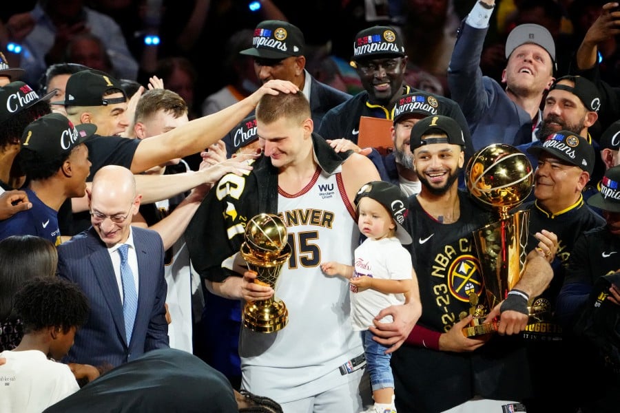  Denver Nuggets center Nikola Jokic holds his daughter as he celebrates winning the Bill Russell NBA Finals MVP Award after the Nuggets won the 2023 NBA Championship against the Miami Heat at Ball Arena. - REUTERS PIC