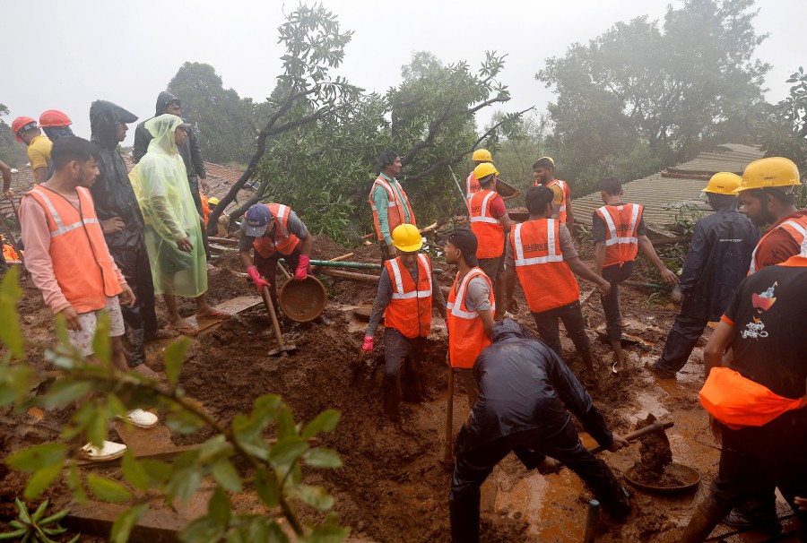 Members of rescue teams clear the debris as they search for survivors after a landslide following heavy rains in Raigad district in the western state of Maharashtra, India. -REUTERS PIC