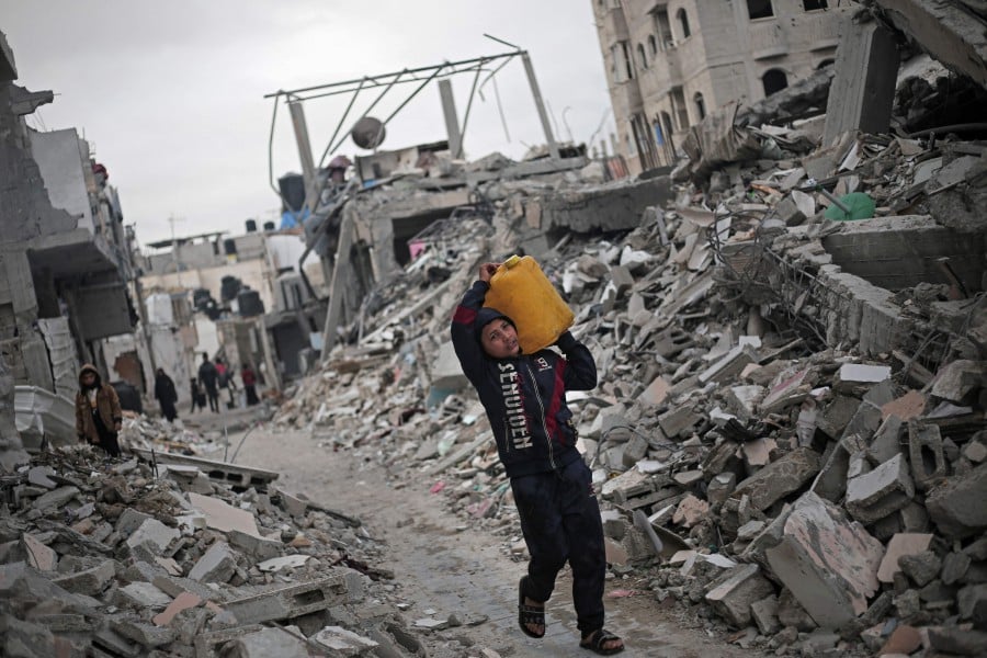 A Palestinian boy carries a water container amid the rubble of houses destroyed by Israeli bombardment in Rafah in the southern Gaza Strip. Malaysian Deputy Foreign Minister Datuk Mohamad Alamin, at the Human Rights Council in Geneva, told of witnessing the devastation personally as he reiterated Malaysia’s call for a permanent ceasefire. AFP pic