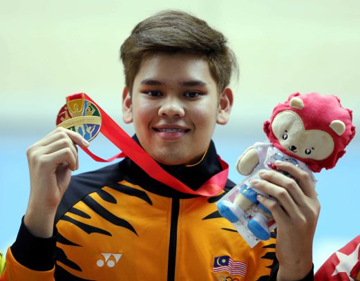 National bowler Rafiq Ismail poses with his gold medal won at the 2015 Singapore Sea Games. Pix by ROSLI RAHMAT
