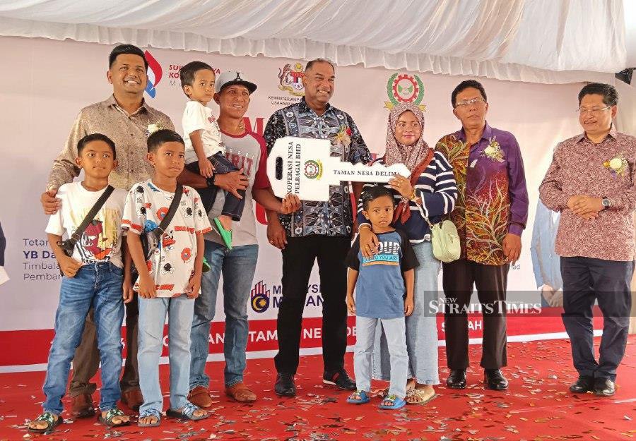Deputy Entrepreneur Development and Cooperatives Minister Datuk R Ramanan (in batik shirt) handing over the mock keys for home buyers in Taman Nesa Delima Rantau, in Rembau today. Pic by Mohd Amin Jalil