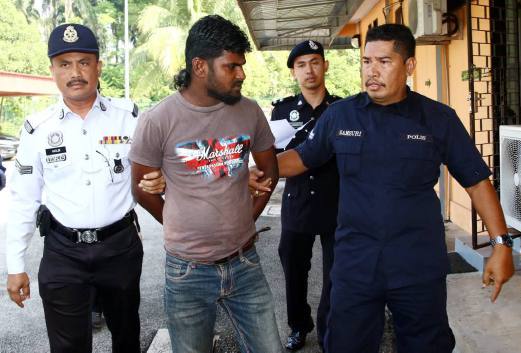 G. Mathan, 30, accompanied by police out of the Jawi Magistrate's court, Nibong Tebal. Pix by Amir Irsyad Omar