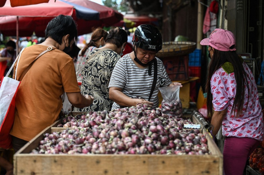 In this photo taken on January 19, 2023, shows customers shopping for onions at a market in Manila. - AFP PIC