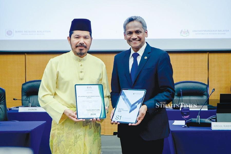Bank Negara Malaysia governor Datuk Abdul Rasheed Ghaffour with Statistics Department chief statistician Datuk Seri Dr Mohd Uzir Mahidin (left) at the announcement of the country’s first quarter economic performance yesterday. PIC BY ASYRAF HAMZAH