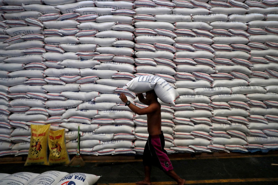 (FILE PHOTO) A worker carries on his head a sack of rice inside a government rice warehouse National Food Authority in Quezon city, Metro Manila in Philippines. (REUTERS/Erik De Castro/File Photo)
