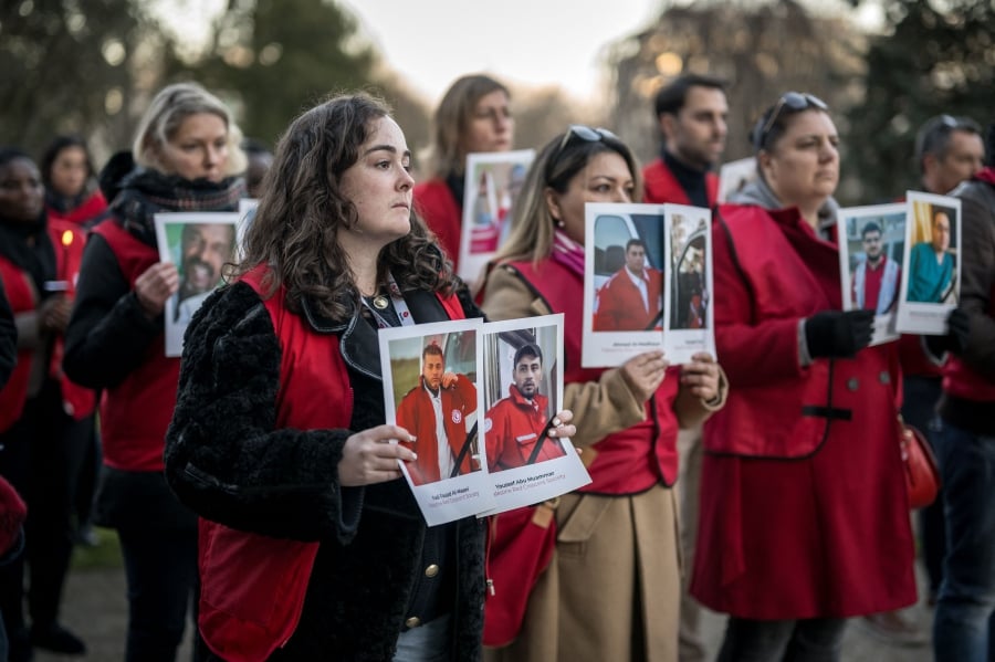 International Federation of Red Cross and Red Crescent Societies (IFRC) staff hold pictures of their 31 staff and volunteers lost while performing their humanitarian duties  during an event to honour their memories, and to raise awareness on the urgent need to protect humanitarians everywhere, in Geneva on Wednesday. - AFP PIC