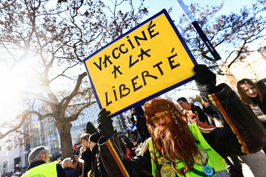 A demonstrator wearing a yellow vest holds a sign reading "Vaccinated to freedom" as he gathers with other protestors at the Place d'Italie in Paris. - AFP PIC