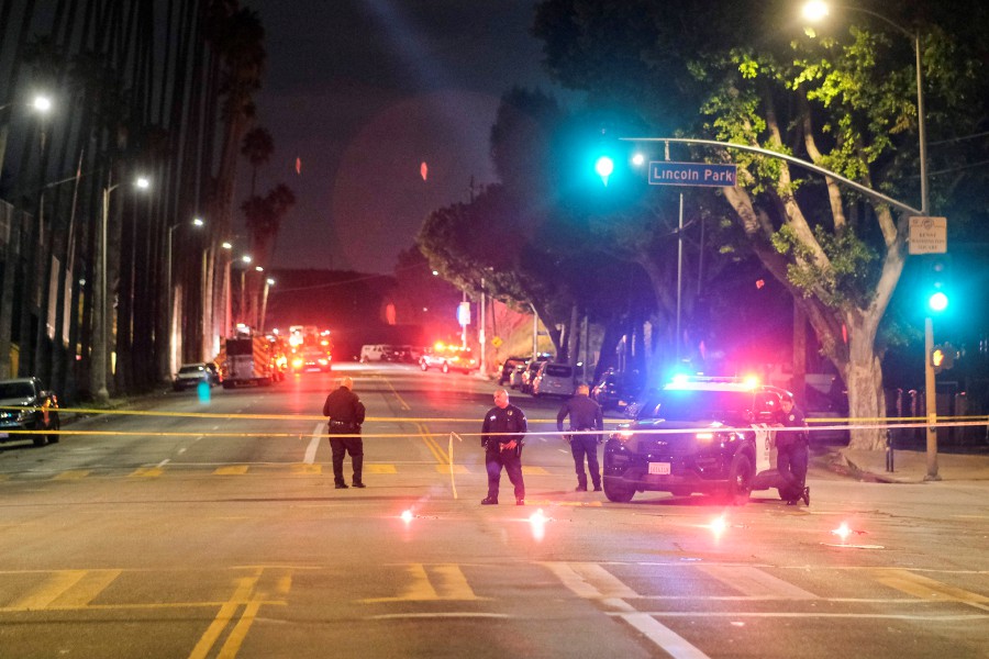 Police officers stand guard near a crime scene where three Los Angeles police officers were shot, in Los Angeles. - AP PIC