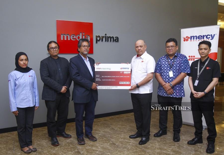  Media Prima Bhd (MPB) chairman Datuk Seri Dr Syed Hussian Aljunid (3rd-right) handing over a mock cheque to Mercy Malaysia president Datuk Dr Ahmad Faizal Mohd Perdaus (3rd-left), during the ceremony at The New Straits Times Press (Malaysia) Bhd (NSTP), Balai Berita, Bangsar. Also present are Mercy Malaysia Deputy director Hafiz Amirrol, MPB group corporate communications general manager Azlan Abdul Aziz (2nd right) and MPB Group Corporate Communications Department executive officer Farris Effendy. - NSTP/AZIAH AZMEE