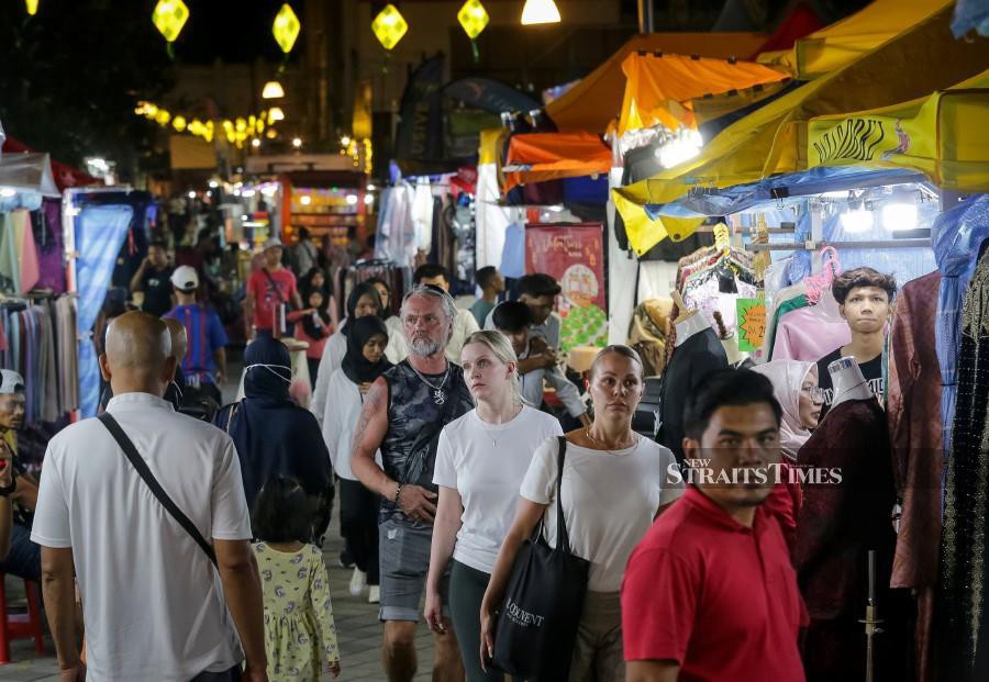 Foreigners and locals visit the Aidilfirti bazaar along Lorang TAR in Kuala Lumpur. -NSTP/ASYRAF HAMZAH