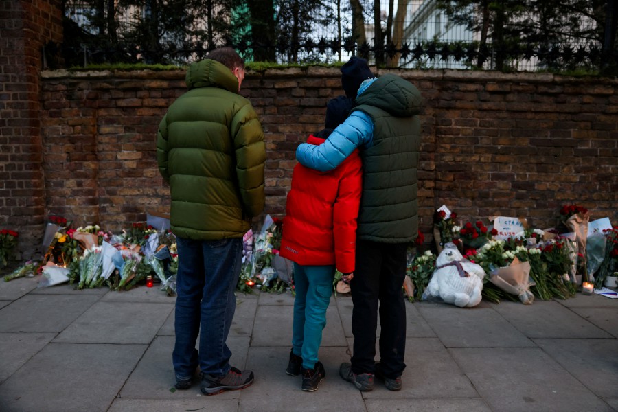 People stand next to tributes to the victims of a shooting at the Crocus City Hall concert venue in the Moscow Region, outside the Russian embassy in London, Britain. - REUTERS PIC