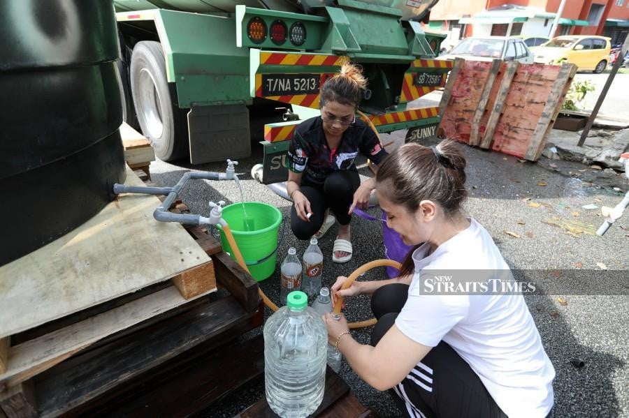 Residents of Bandar Baru Perda flats in Teluk Kumbar, fill up their water containers following the water disruption in Penang. -NSTP/MIKAIL ONG