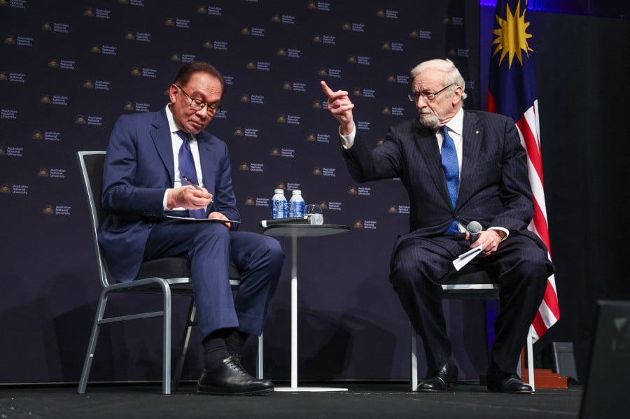 Malaysia's Prime Minister Datuk Seri Anwar Ibrahim (L) sits with former Australian Foreign Minister Gareth Evans during an event at the Australian National University (ANU) in Canberra. - AFP PIC