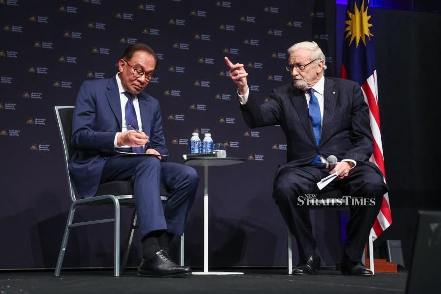 Malaysia's Prime Minister Anwar Ibrahim (L) sits with former Australian Foreign Minister Gareth Evans during an event at the Australian National University (ANU) in Canberra on March 7, 2024. (Photo by DAVID GRAY / AFP)