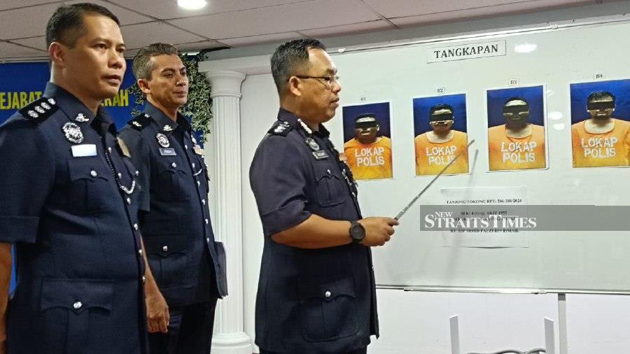 Northeast district police chief Assistant Commissioner Razlam Ab Hamid pointing a pictures of the suspects, during a press conference in George Town. -NSTP/ FOTO ZUHAINY ZULKIFFLI