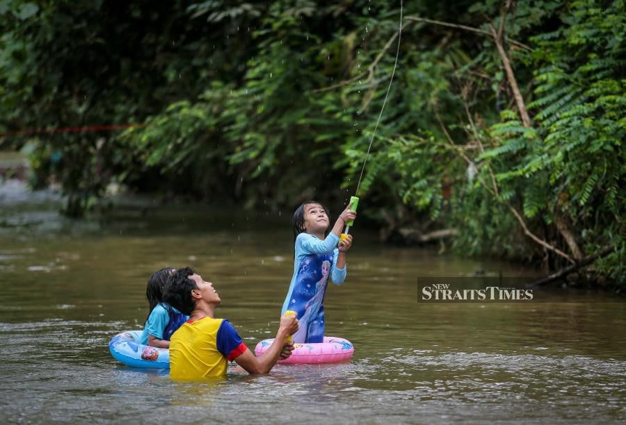 A family enjoys a day out at Tampler's Park, seeking relief from the hot weather in Kuala Lumpur. - NSTP/ASWADI ALIAS