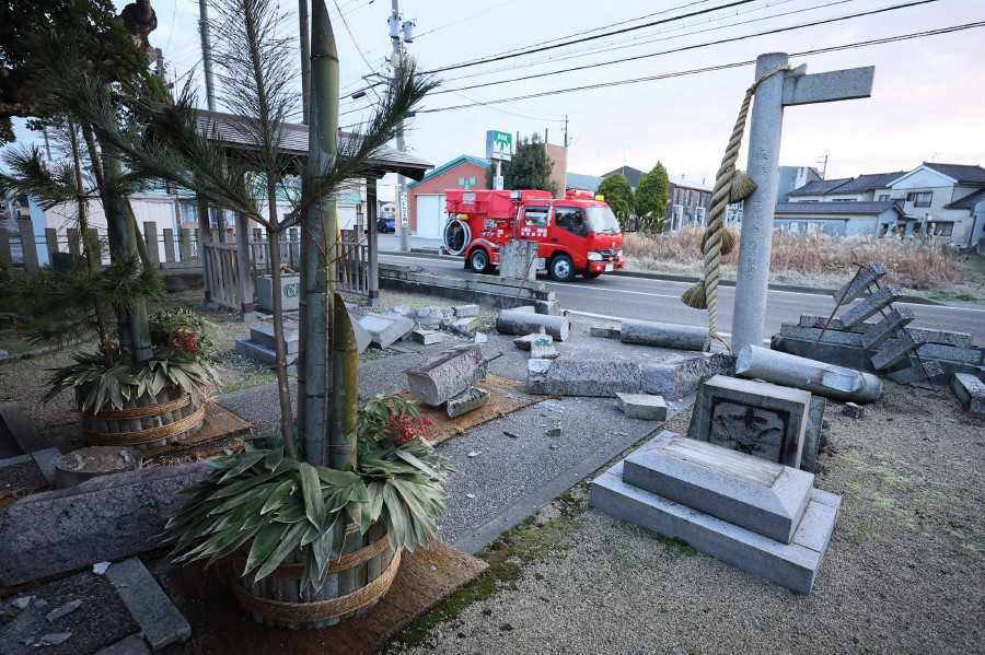An emergency vehicle is pictured in front of a shrine where a large stone gate, or "torii" has collapsed in the city of Nanao, Ishikawa prefecture. - AFP PIC