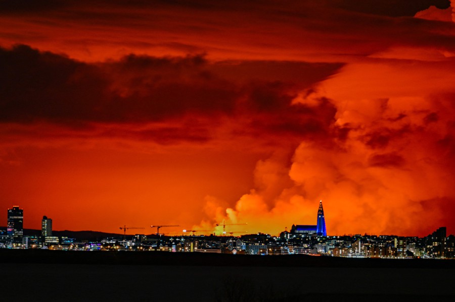 The skyline of Reykjavik is against the backdrop of orange coloured sky due to molten lava flowing out from a fissure on the Reykjanes peninsula north of the evacuated town of Grindavik, western Iceland on March 16, 2024. -AFP PIC