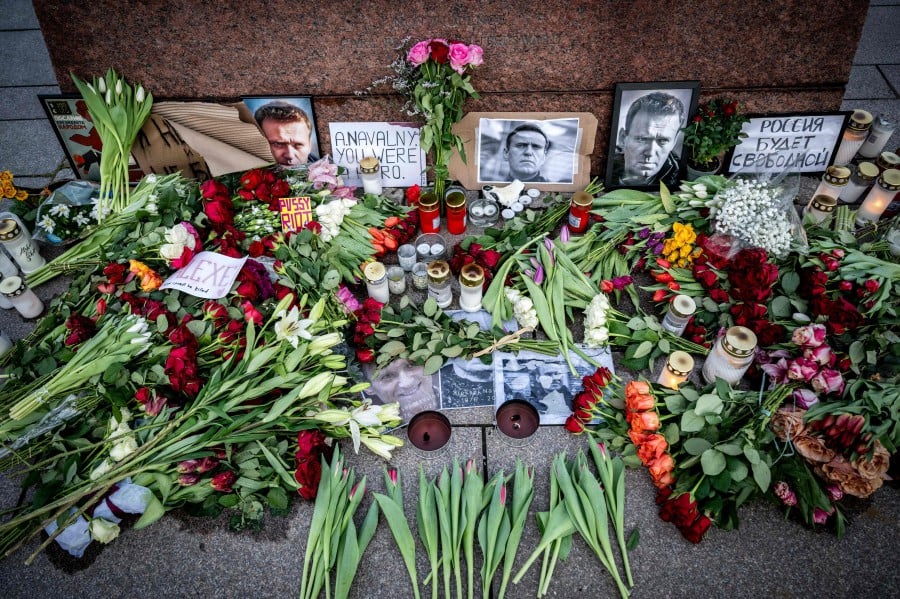 Flowers, candles and portraits of late Russian opposition leader Alexei Navalny, who died in a Russian Arctic prison, lay at a makeshift memorial at Carl Fredrik Reutersward's sculpture 'Non-Violence' at Anna Lindhs Place in Malmo, Sweden. - AFP PIC