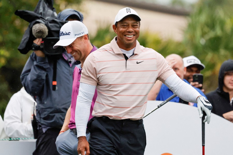 Tiger Woods laughs at a comment made by playing competitor Justin Thomas (back) on the sixth tee box during the PNC Championship at The Ritz-Carlton Golf Club. --REUTERS PIC
