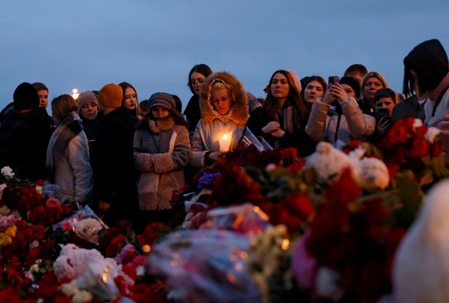 People gather at a makeshift memorial to the victims of a shooting attack set up outside the Crocus City Hall concert venue in the Moscow Region, Russia. - REUTERS PIC