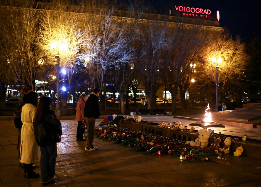 People stand in front of the eternal flame memorial where flowers and toys are laid in memory of the victims of a shooting attack at the Crocus City Hall concert venue outside Moscow, in Volgograd, Russia. - REUTERS PIC