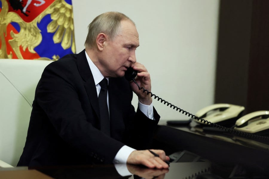 Russian President Vladimir Putin speaks on the phone as he delivers a video address to the nation following a shooting attack at the Crocus City Hall concert venue, at an unidentified location in Russia. - REUTERS PIC